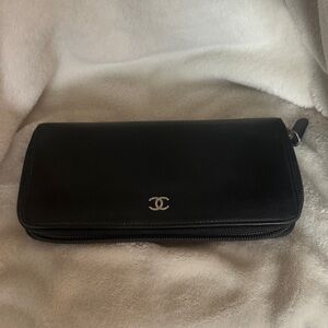 CHANEL black zip wallet in caviar leather with silver-tone hardware.